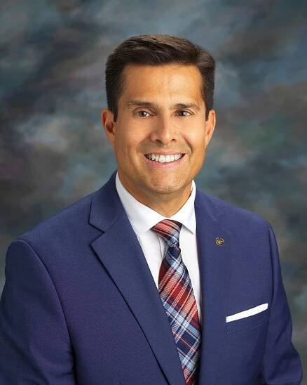 A man in a suit and tie is smiling for the camera.