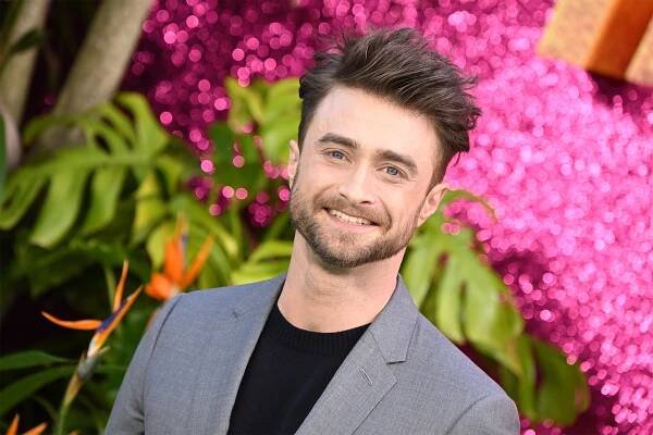 "Merrily We Roll Along" star Daniel Radcliffe smiles on the red carpet.
