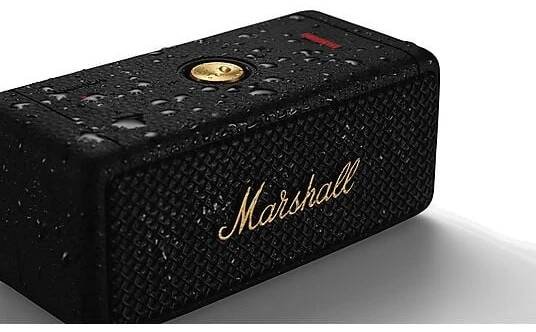 Schwarzer Marshall-Lautsprecher mit goldenem Logo. Wassertropfen auf der Oberfläche.