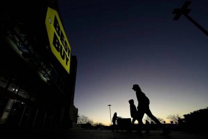 FILE - People are silhouetted against the sky at dawn as they attend a sale at a Best Buy store Friday, Nov. 25, 2022, in Overland Park, Kan. Best Buy reported lower fourth-quarter sales and net income, Thursday, Feb. 29, 2024, as shoppers remain cautious about spending on gadgets. (AP Photo/Charlie Riedel, File)