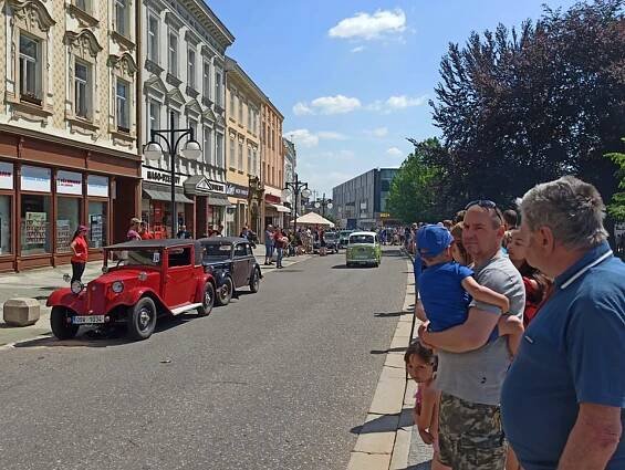 Lidé se dívají na spanilou jízdu veteránů.
