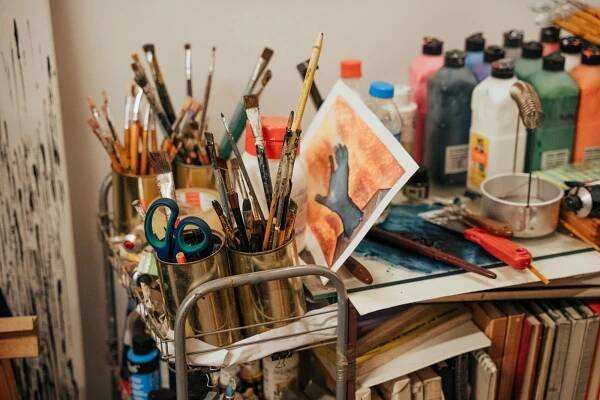 bezplatná Barevný koutek uměleckého studia se štětci, barvami a malovaným plátnem. Ideální pro kreativní inspiraci. Základová fotografie