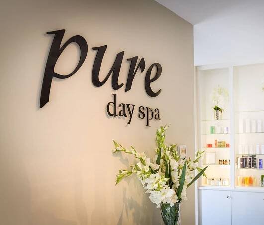 A sign on a wall that says pure day spa