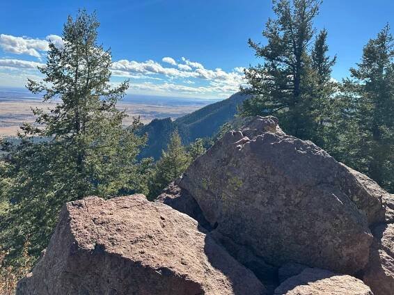 Two large boulders at the peak of Green Mountain. In the distance you can see Bear Peak.