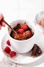 mocha mug cake with spoon and raspberries