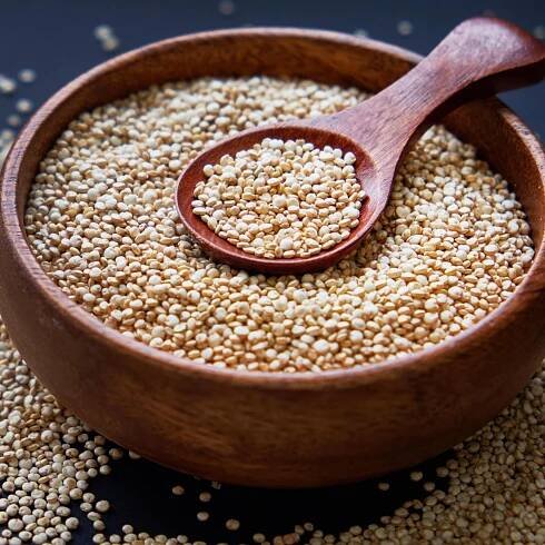 Quinoa in einer Holzschüssel mit einem Löffel