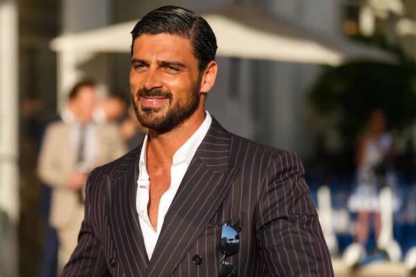 A Man In A Suit Smiling Outside
