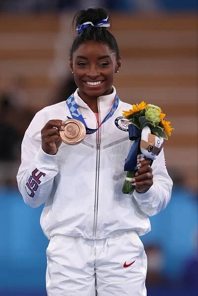 Simone Biles of Team United States poses with the bronze medal during the Women's Balance Beam Final medal 