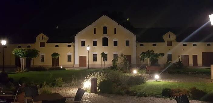 a large white building with a courtyard at night at Statek 1738 in Všestudy