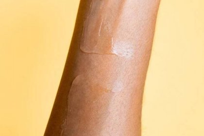 Two sunscreens are rubbed in a little more on an arm.
