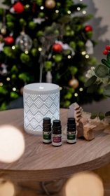 essential oils on a table in front of a christmas tree