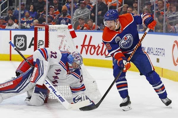 Jonathan Quick, who had 29 saves, covers up the puck in front of Zach Hymann during the Rangers' 3-0 win over the Oilers.