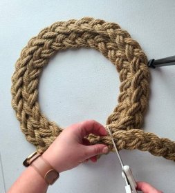 Cutting the excess braided rope off of the wreath.