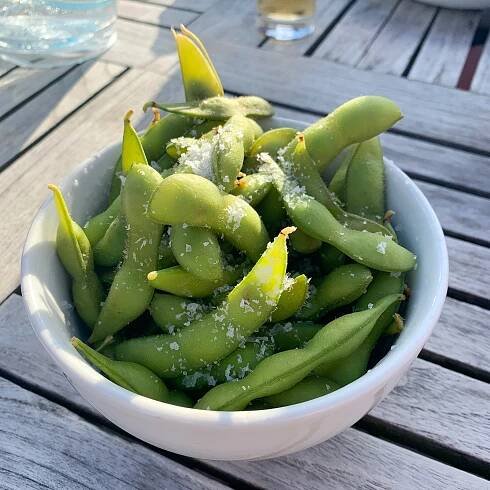 Edamame sind unreif geernteten Sojabohnen, sie werden noch in der Hülse steckend gegart und am besten mit grobkörnigem Meersalz angerichtet und gegessen.