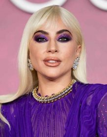 Lady Gaga platinum hair with bangs, glittery purple eyeshadow, and sparkly lipstick