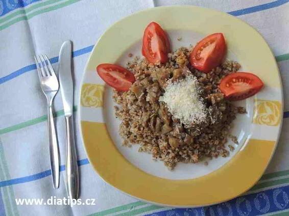 houbový bulgur ozdobený rajčetem na talířu
