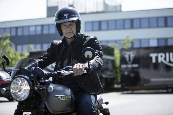 Actor Simon Licht driving Triumph motorcycle