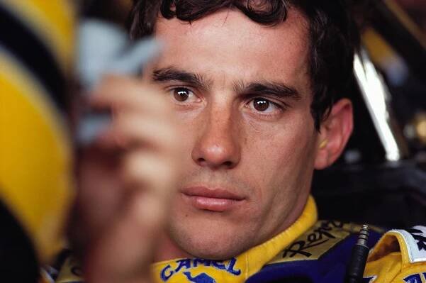 Ayrton Senna strapped to his Lotus cockpit during a practice session
