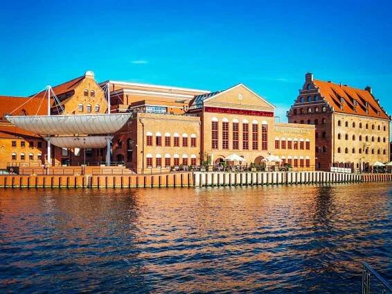 Die Danziger Philharmonie, gelegen am Ufer der Mottlau, ein modernes Gebäude, das kulturelle Veranstaltungen und Konzerte von Weltrang bietet.