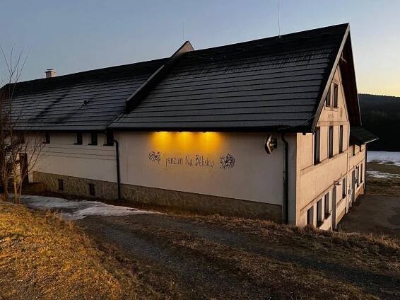 a building with writing on the side of it at Penzion Na Bělisku in Březiny