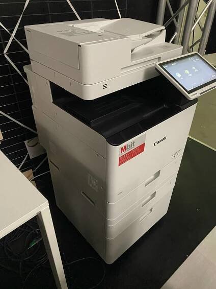 Ein getesteter Laserdrucker-WLAN von schräg vorne auf einer dunklen Fläche stehend.