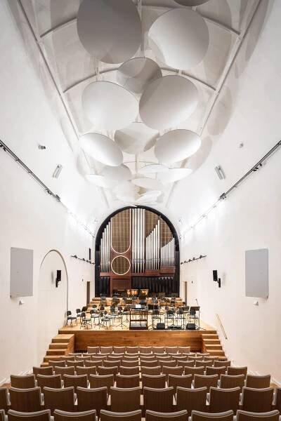 Dechberoucí proměna bývalého kostela na sál Jihočeské filharmonie. Moderní minimalismus a netradiční barvy