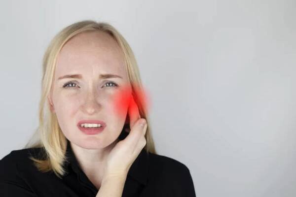 žena trpí bolestí v uchu. sluchový meatus bolí v důsledku zánětu středního ucha, cerumenové zátky, ušního varu nebo trigeminální neuralgie. na vyšetření lékařem. - vnější zvukovod - stock snímky, obrázky a fotky