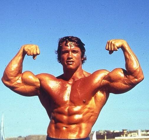 a man flexing his muscles on the beach