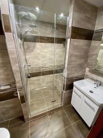 Koupelna v paneláku s prostorným sprchovým koutem se sedátkem