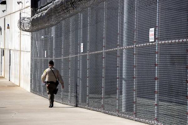 A guard walks inside the perimeter of Mule Creek State Prison in Ione, Calif.