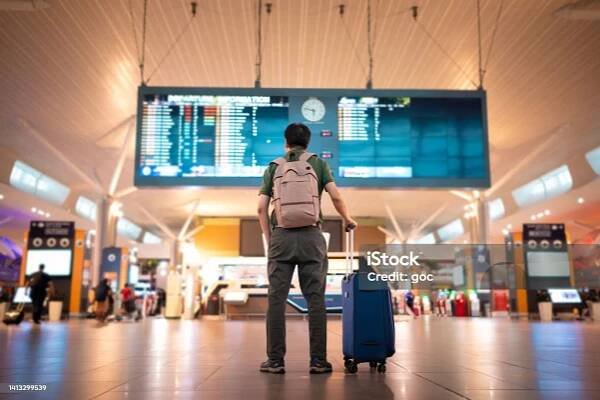 Mužský turista při pohledu na příletovou a odletovou tabuli na mezinárodním letišti Kuala Lumpur - Bez autorských poplatků Letiště Stock fotka