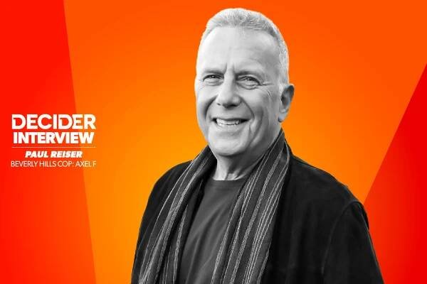 Paul Reiser in black and white on a bright orange background