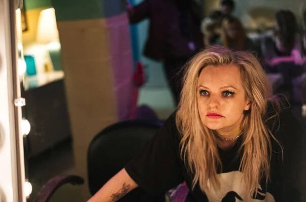 Elizabeth Moss looks at herself in the mirror.