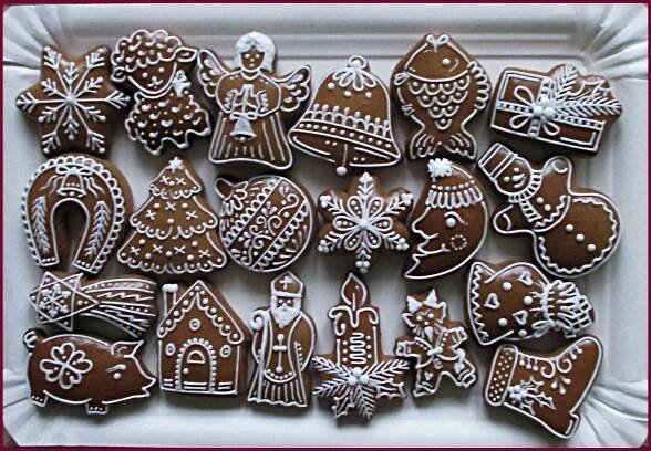 a white tray filled with lots of decorated gingerbread cookies on top of a table