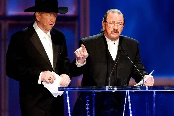 Terry Funk stands in front of a podium as he is inducted in to W.W.E. Hall of Fame.