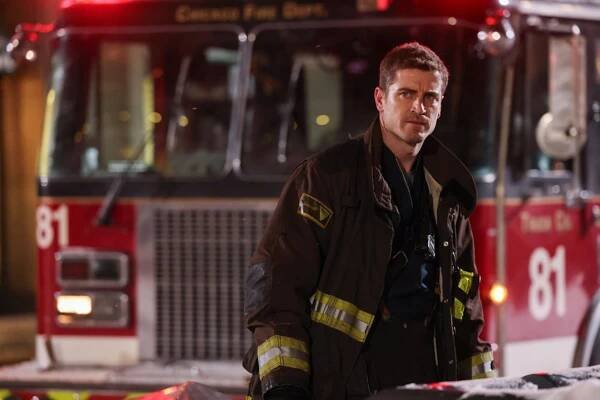 Jake Lockett as Sam Carver standing in front of a fire truck on 'Chicago Fire'