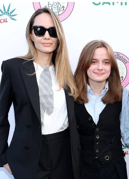 Angelina Jolie Pitt wears sunglasses as she stands next to daughter Vivienne Jolie-Pitt.