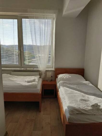 two beds in a room with a window at Penzion Patria Kobyli in Kobylí