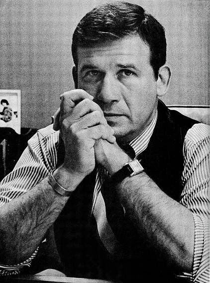 A black and white photo of Richard Carlson, wearing a striped shirt and a dark vest, and looking at the camera.