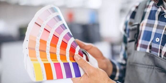 Man working in printing house with paper and paints