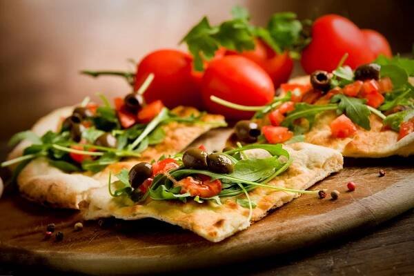 Stáhnout - Foto vynikající vegetariánské pizzy s rukolou na dřevěný stůl — Stock obrázek