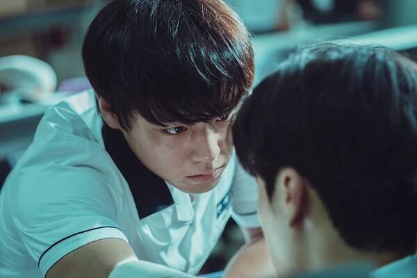 Park Ji-hoon as Si-eun wears a school uniform while staring at a fellow student in an image from ‘Weak Hero Class 1.’