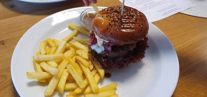 Hovězí burger v briošce se sýrem, cibulí a salátem, podávaný s hranolkami a dipem – obědová nabídka BISTRO SOUD