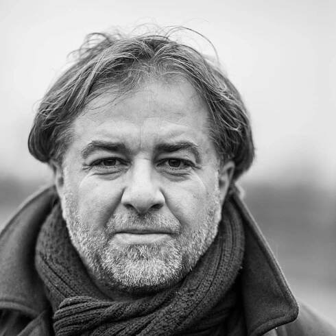 Ein Schwarz-Weiß-Porträt von Miloš Doležal, der einen Schal und einen Mantel trägt.