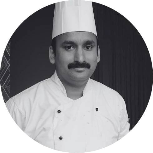 A black and white photo of a chef in a circle