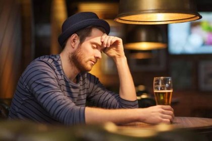 Nešťastný osamělý muž pít pivo na bar či hospodu