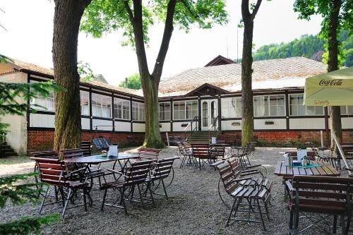 a group of tables and chairs in front of a building at Hotel Praha Potštejn in Potštejn