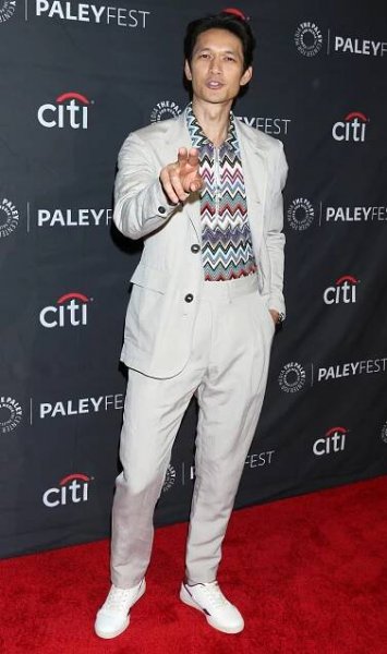 Harry Shum Jr. brings casual elegance to PaleyFest LA with a patterned shirt, light beige suit, and crisp white sneakers