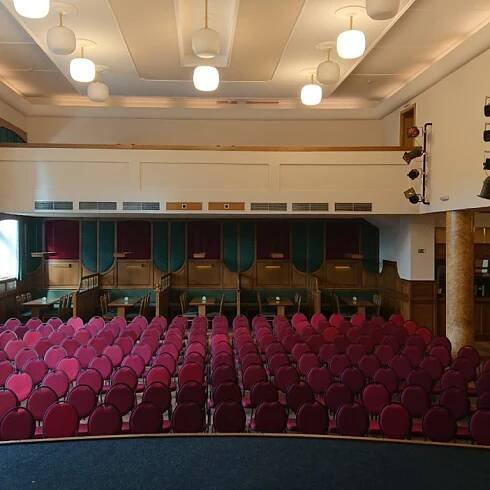 Pohled ze scény na uspořádání židlí pro konferenci nebo přednášku ve společenském sále Beseda v Českých Budějovicích