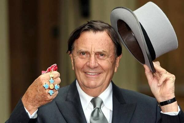 Dr Barry Humphries poses for pictures after he received his Most Excellent Order of the British Empire from the Queen at Buckingham Palace, in central London, 10 October 2007. Humphries is an Australian comedian best known for the television charachter Dame Edna Everage. AFP PHOTO/Steve Parsons/POOL (Photo credit should read Steve Parsons/AFP via Getty Images)